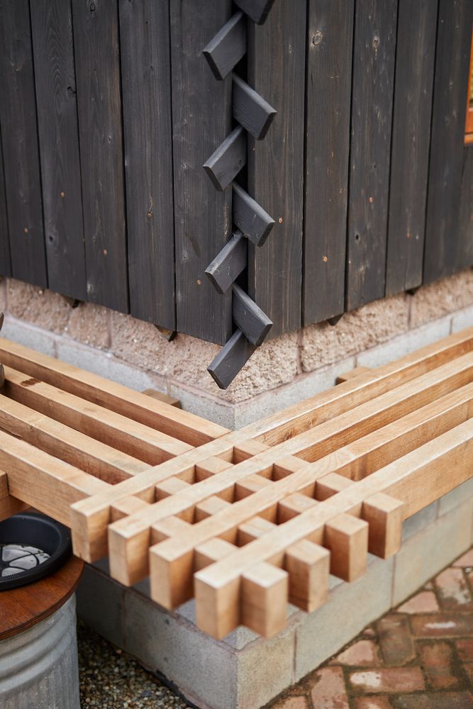 a wooden bench sitting next to a building