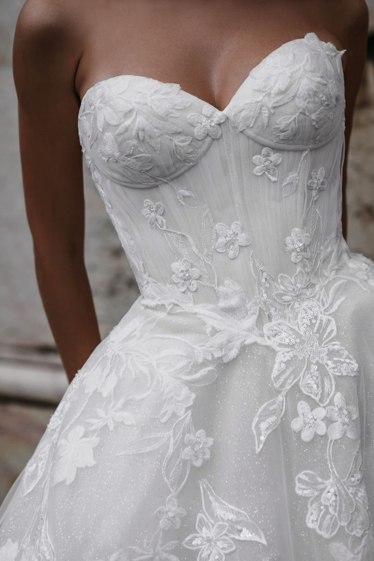 a woman in a white wedding dress with flowers on it