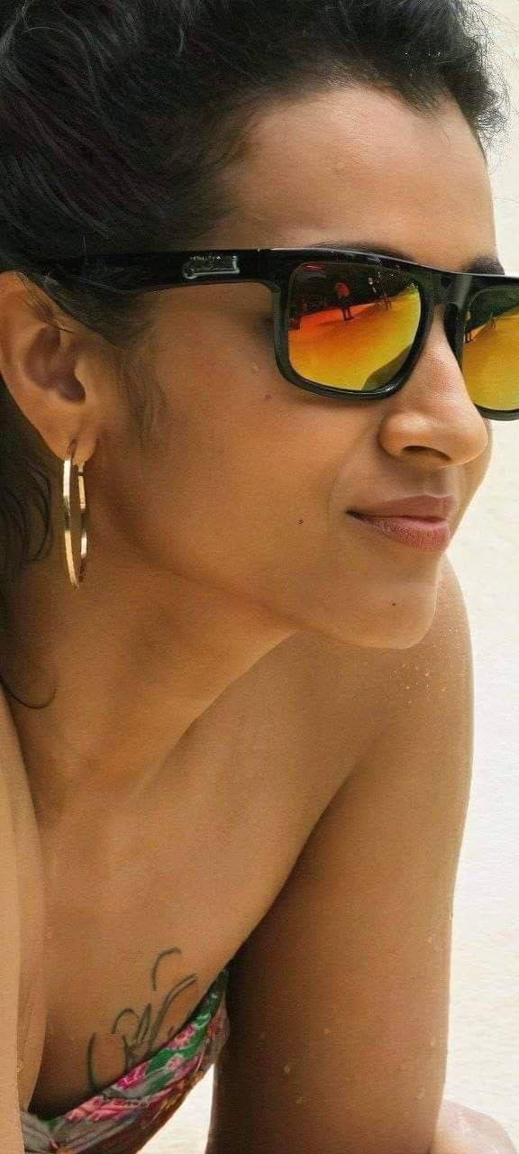 a woman wearing sunglasses laying on the beach