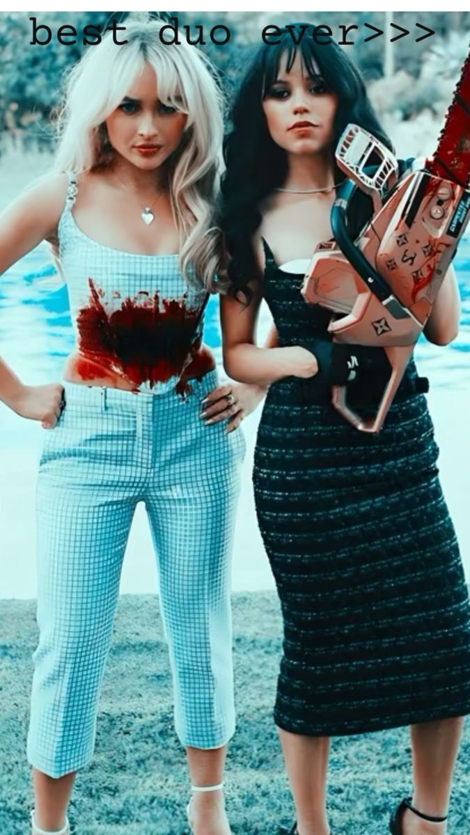 two women standing next to each other in front of a pool with blood on them