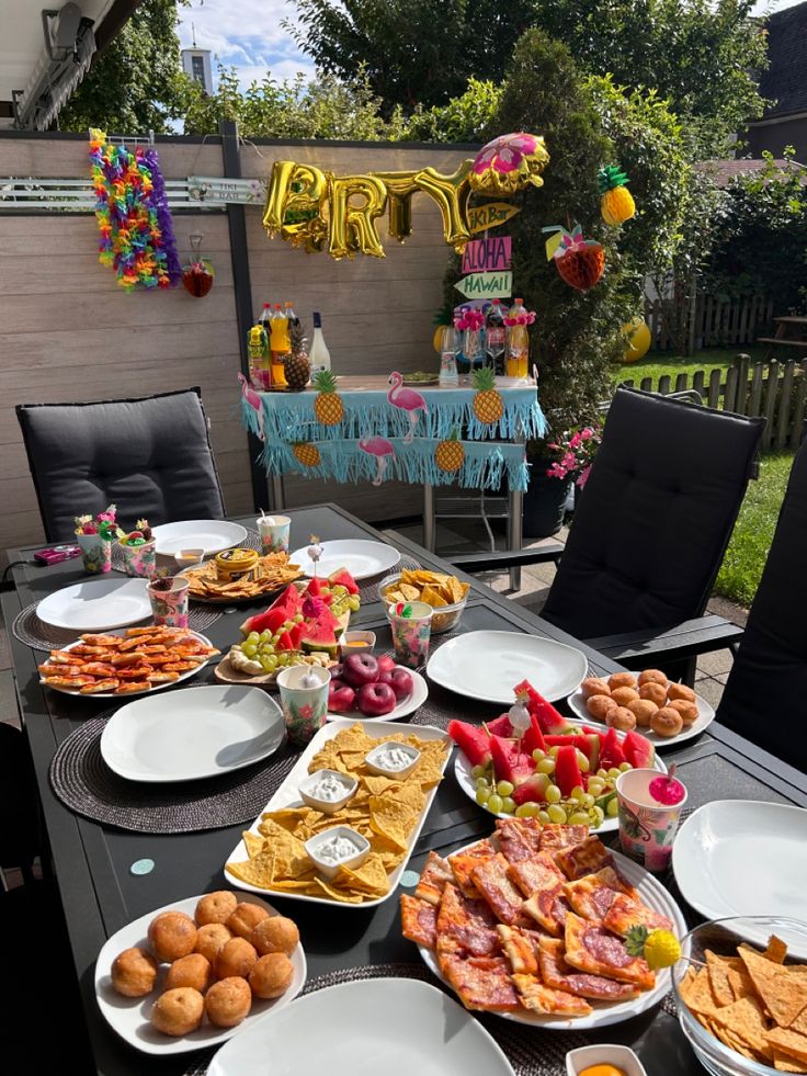 a table full of food with balloons in the background