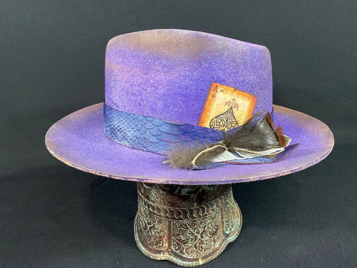 The Manhattan Fedora 4 1/2 Crown, 2 3/4 Upturned Brim Custom Color and Distressing Handmade Custom Leather Band and Accessories 4x Premium Firm Felt Although each hat is unique a similar hat can be made in various sizes. RevRanHat Size Chart Small - 6 7/8 Medium - 7 1/8 Large - 7 3/8 XL - 7 5/8 Handmade Formal Hat With Curved Brim, Formal Handmade Hat With Curved Brim, Custom Formal Hat With Short Brim, Vintage Purple Hat With Short Brim, Vintage Short Brim Purple Hat, Custom Curved Brim Top Hat For Kentucky Derby, Custom Flat Brim Top Hat For Kentucky Derby, Custom Top Hat With Curved Brim For Kentucky Derby, Vintage High Crown Fedora For Kentucky Derby