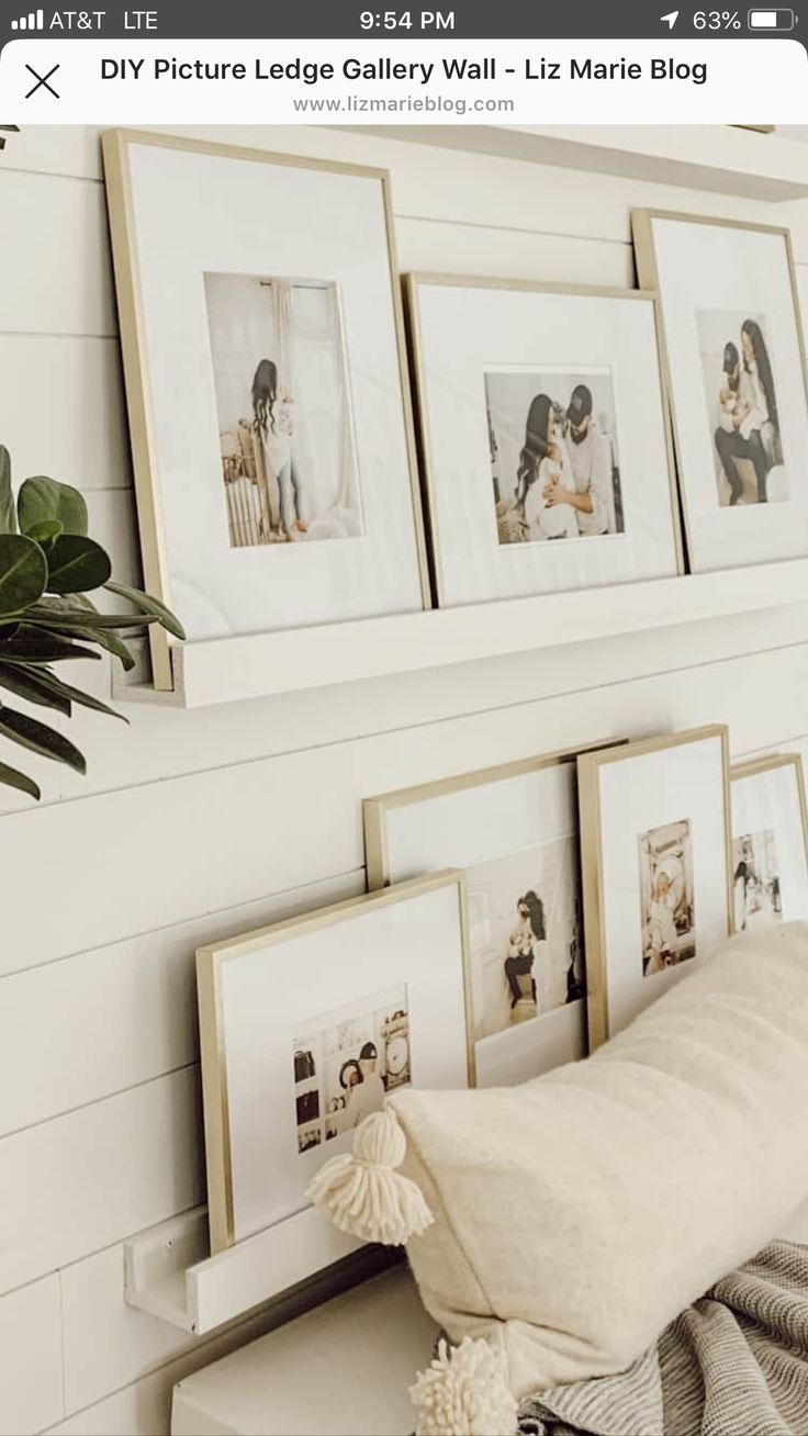 some pictures are hanging on the wall above a bench with a pillow and flowers in front of it