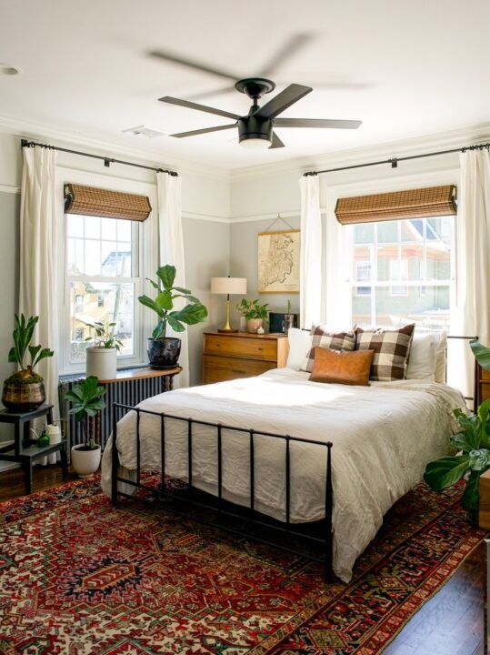 a bedroom with a bed, rug and ceiling fan