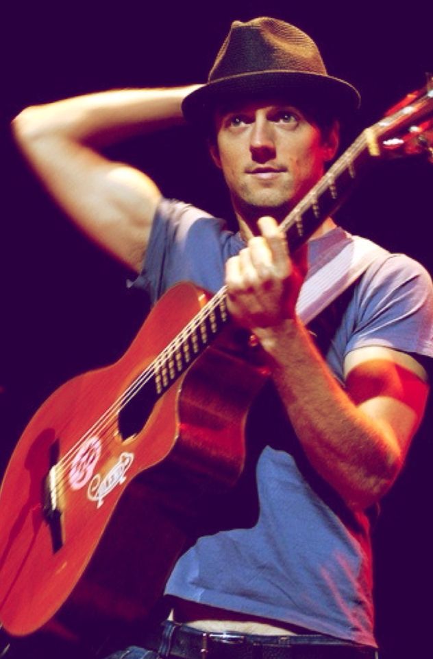 a man with a hat holding a guitar