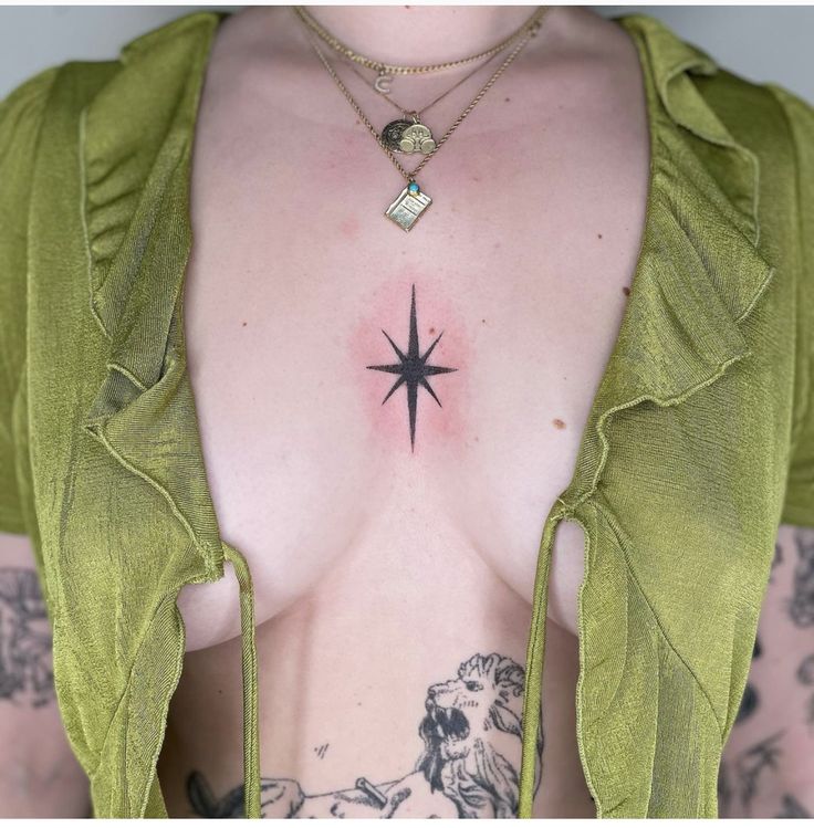 a woman with tattoos on her chest has a star tattoo on her left side and is wearing a green top