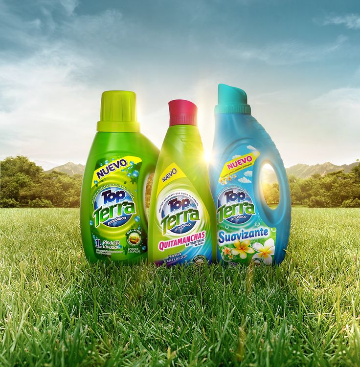 three bottles of detergent sitting in the grass