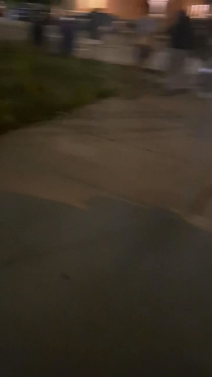 a blurry photo of a person riding a skateboard down a street at night