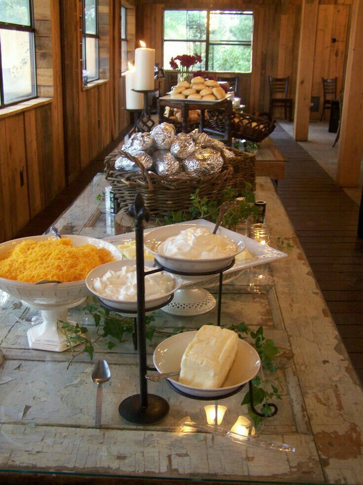 a buffet table filled with lots of food and candles on top of the tables in front of them