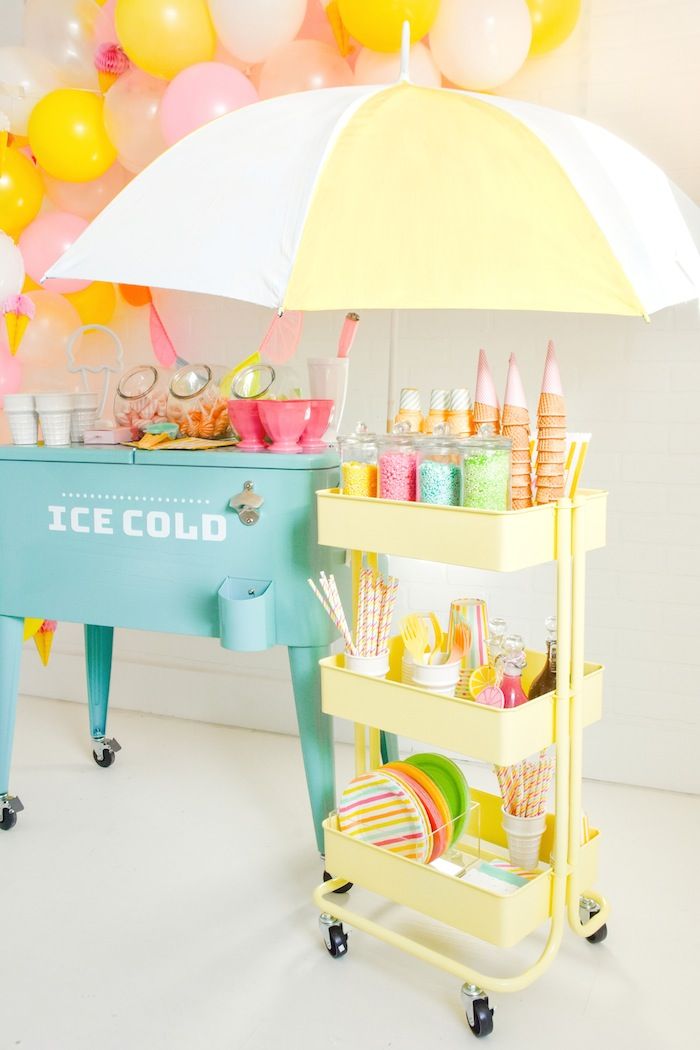 an ice cold cart is set up in front of balloons