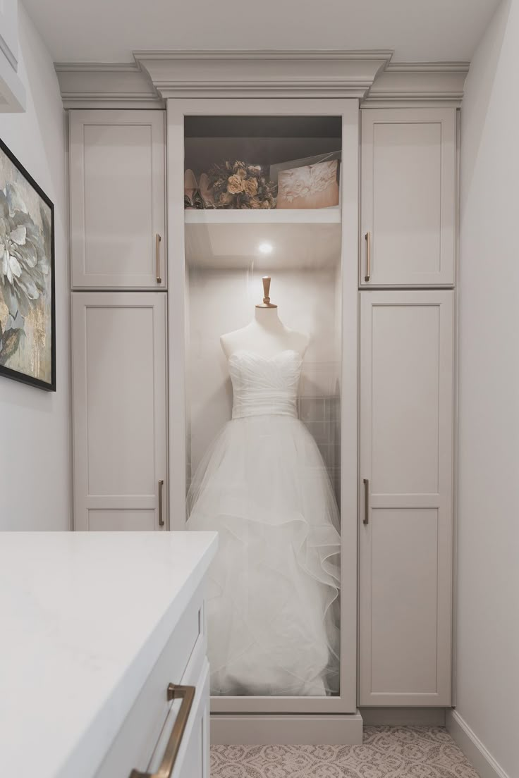 a white wedding dress hanging in a closet