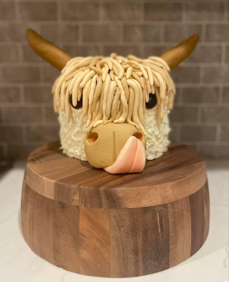 a cake made to look like a cow's head on top of a wooden board