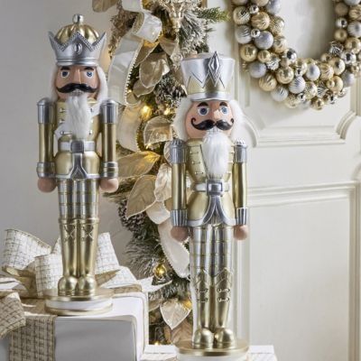 two nutcrackers are standing next to each other near a christmas tree and wreath