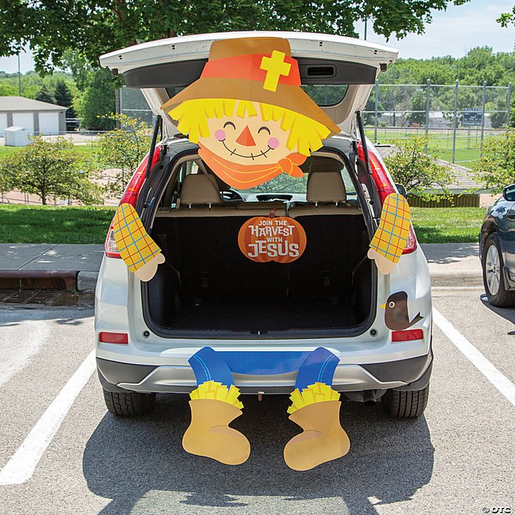 the back end of a car with an inflatable scarecrow on it's trunk