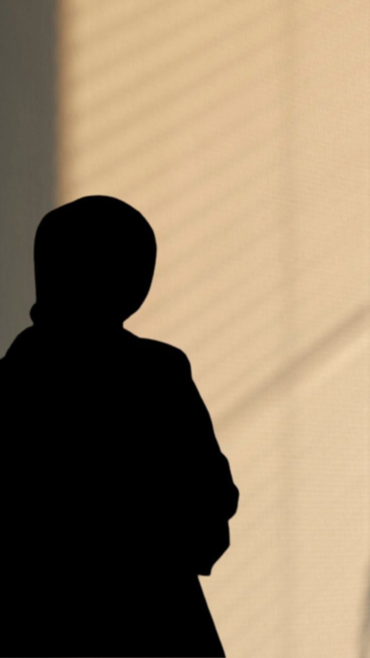 the shadow of a person standing in front of a wall