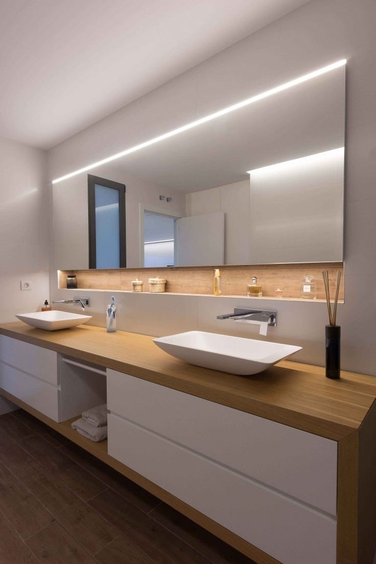 a bathroom with two sinks and a large mirror above it's countertop area