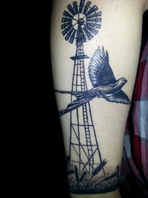 a man with a windmill and bird tattoo on his arm