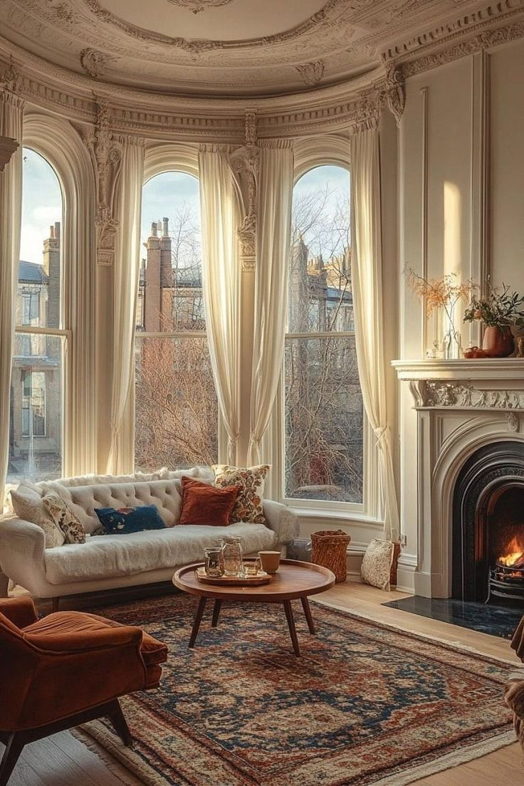 a living room filled with furniture and a fire place in front of a large window