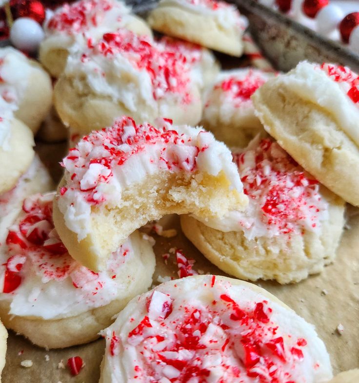 red and white sprinkled sugar cookies on a baking sheet with candy canes