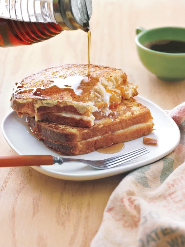 someone is pouring syrup on some french toast