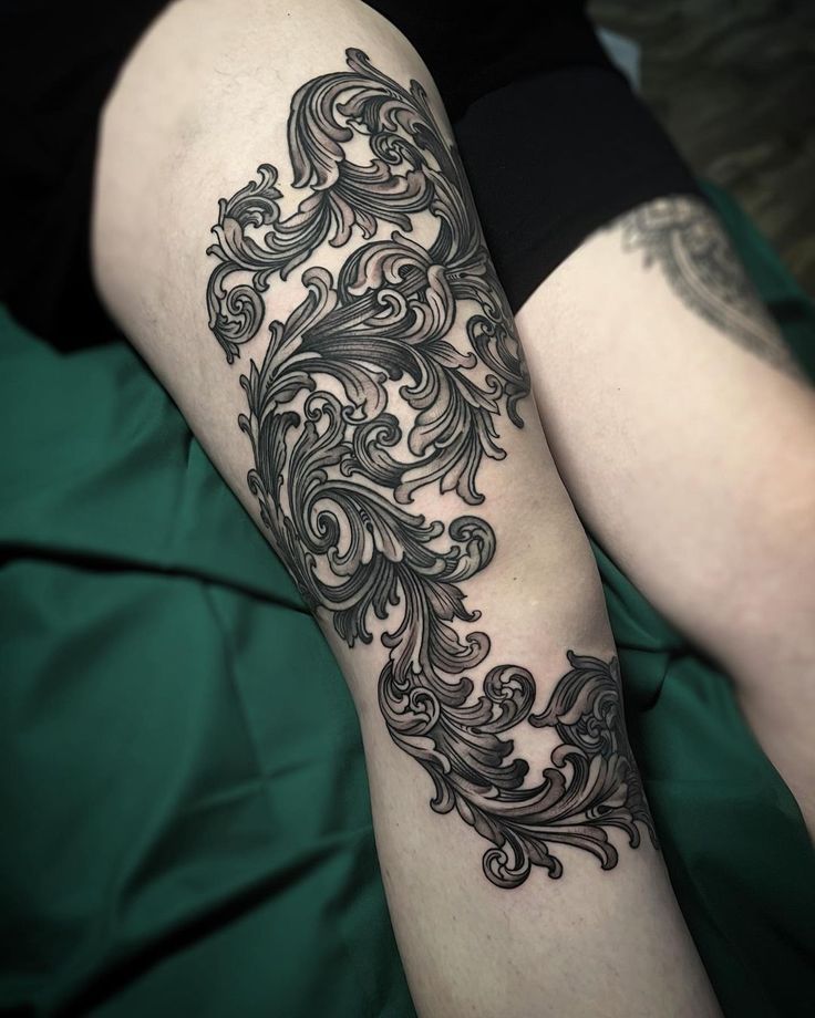 a woman's leg with an intricate tattoo on it