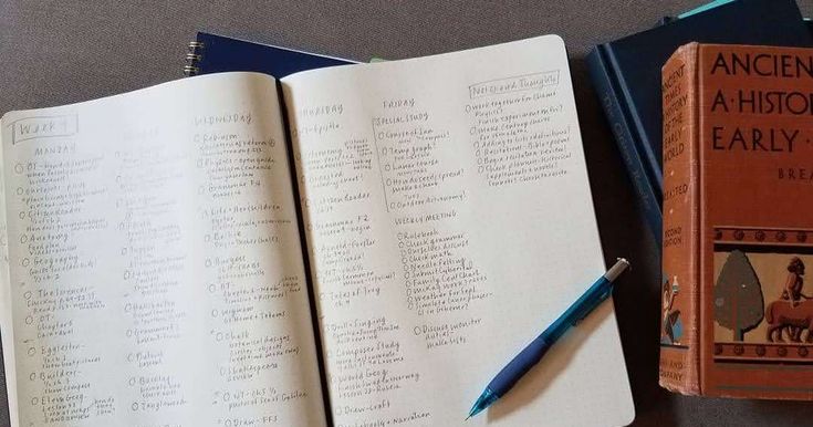 an open book sitting on top of a table next to a pen