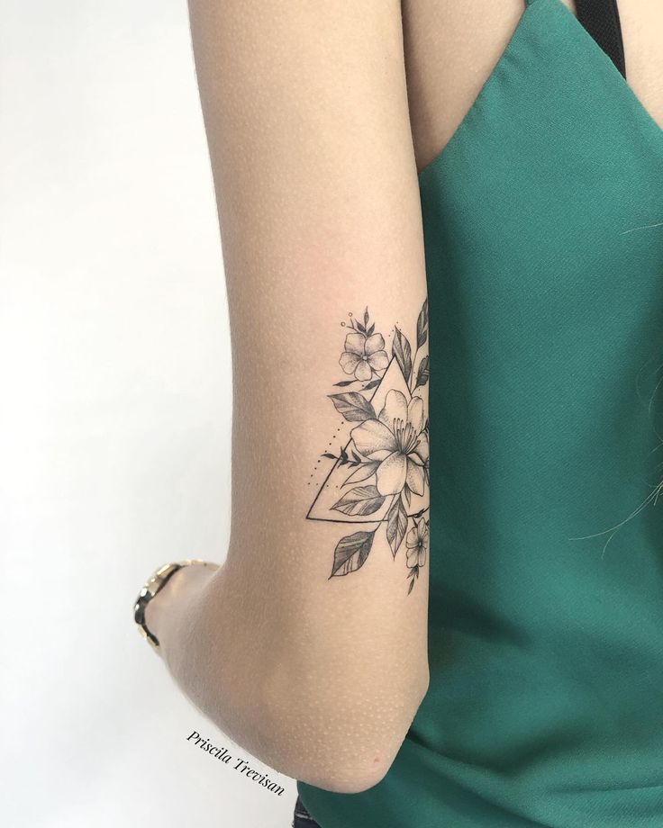 a woman's arm with a flower tattoo on the left side of her arm