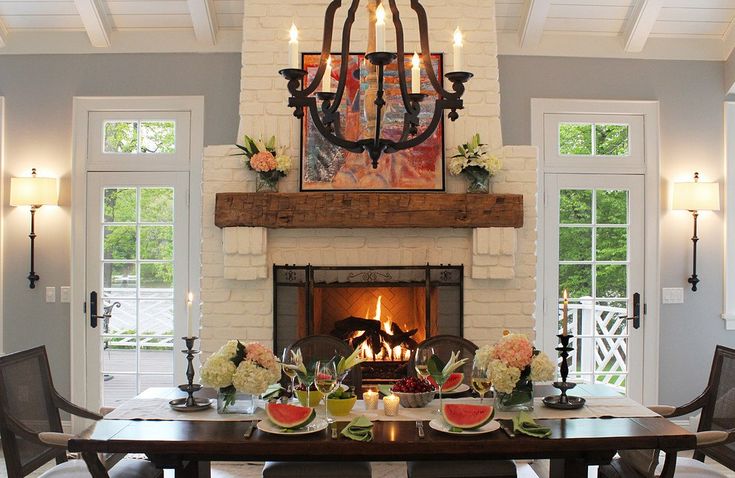 a dining room with a fireplace and chandelier