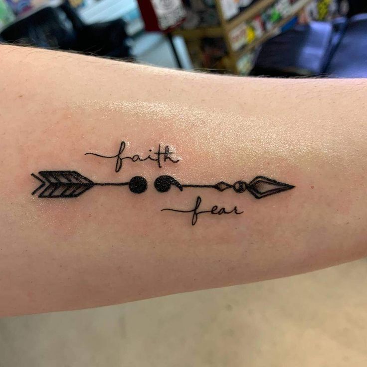 a tattoo that says faith and an arrow