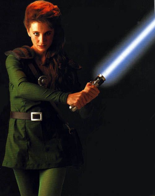 a woman holding a light saber in her right hand and wearing green tights on the other side