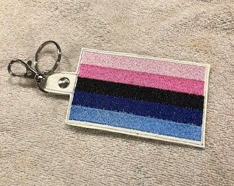 a keychain with a pink, blue, and black stripe on the side