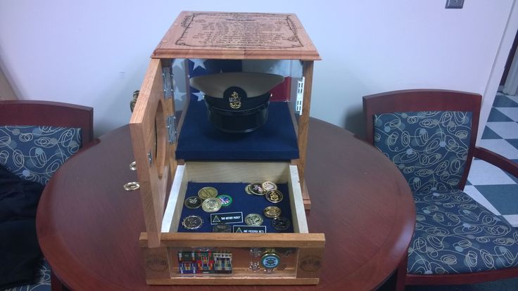 a wooden table topped with an open case filled with coins and other items on top of it