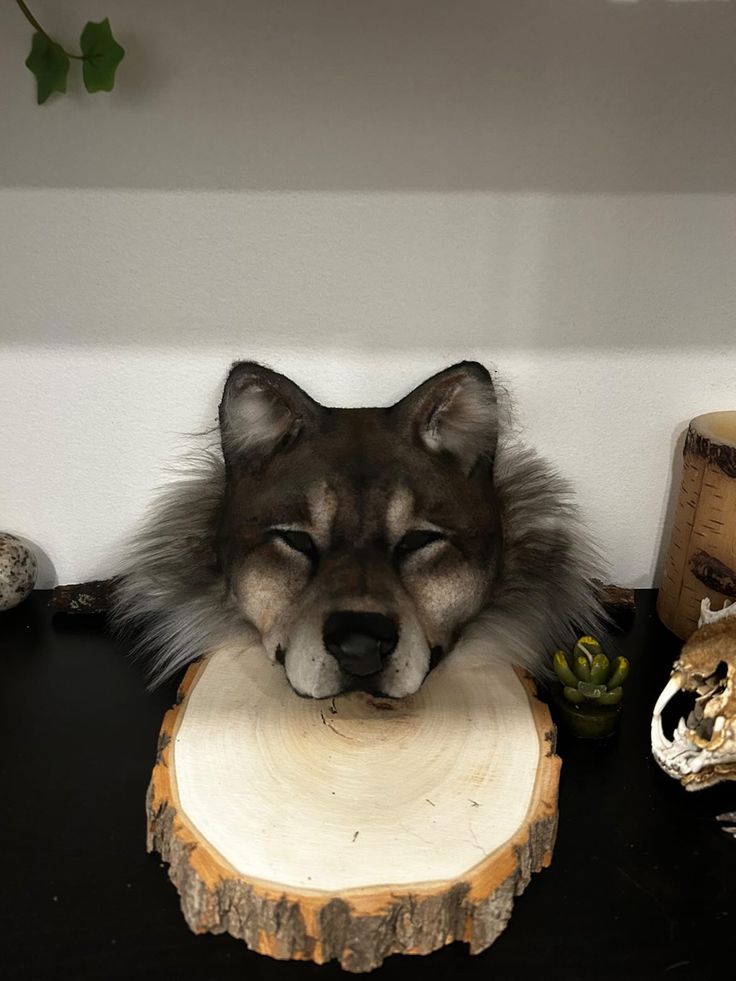 a wolf head sitting on top of a piece of wood