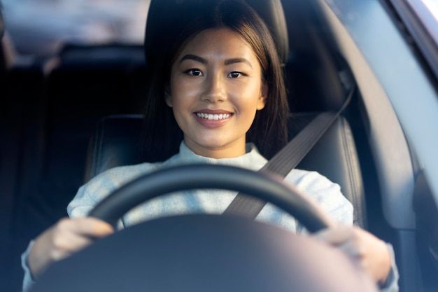 a woman sitting behind the wheel of a car