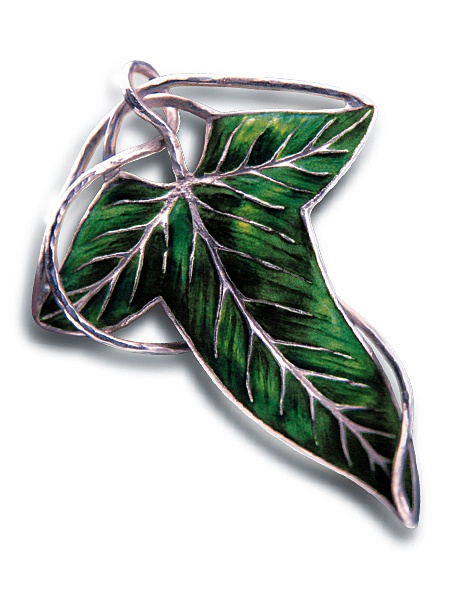 a green leaf shaped brooch sitting on top of a white surface