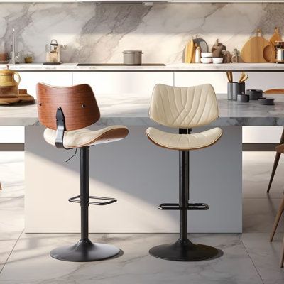 two modern bar stools in front of a kitchen counter