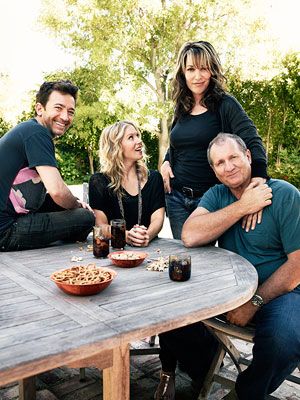 a group of people sitting around a table with food and drinks in front of them