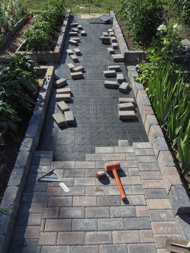 an empty garden with benches and tools laying on the ground