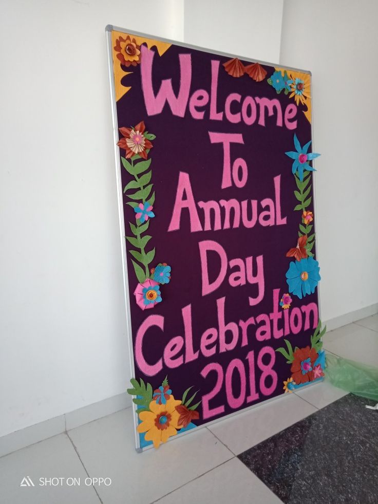 a sign that says welcome to annual day celebration in front of a white wall and tiled floor