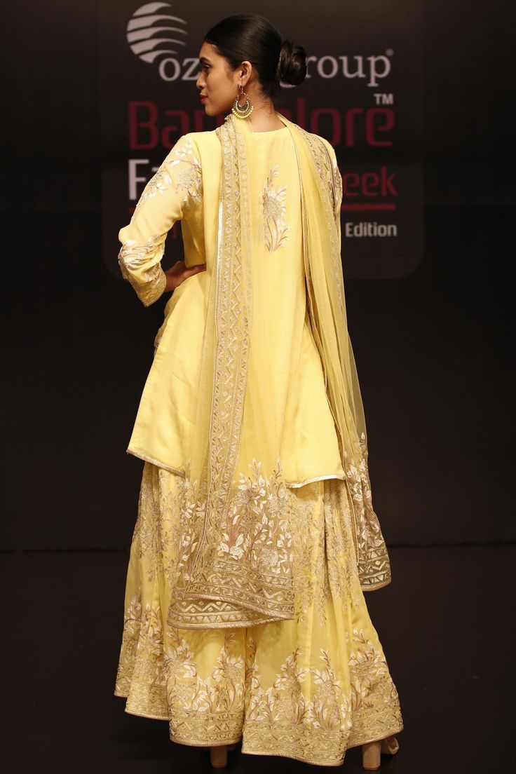 Yellow short kurta with placement floral embroidery. Comes with sharara and dupatta.
Components:3
Embroidered
Neckline:Round
Sleeve Length:Full
Fabric:Georgette
Color:Yellow  
Split neckline
Front buttons
Metallic trim
Embroidered sharara and dupatta - Aza Fashions Yellow Chikankari Embroidered Sharara For Reception, Yellow Chikankari Embroidery Sharara For Reception, Eid Silk Sharara With Intricate Embroidery, Eid Sharara With Intricate Embroidery In Dola Silk, Designer Raw Silk Sharara With Intricate Embroidery, Designer Sharara With Intricate Embroidery In Raw Silk, Chikankari Embroidered Dola Silk Sharara For Reception, Anarkali Sharara With Chikankari Embroidery In Dola Silk, Designer Dola Silk Sharara With Resham Embroidery