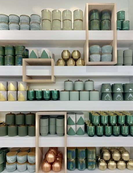 the shelves are filled with many different types of jars and vases in varying colors