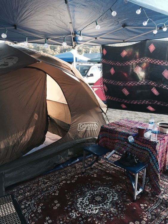 a tent is set up in the middle of an area with rugs and tables