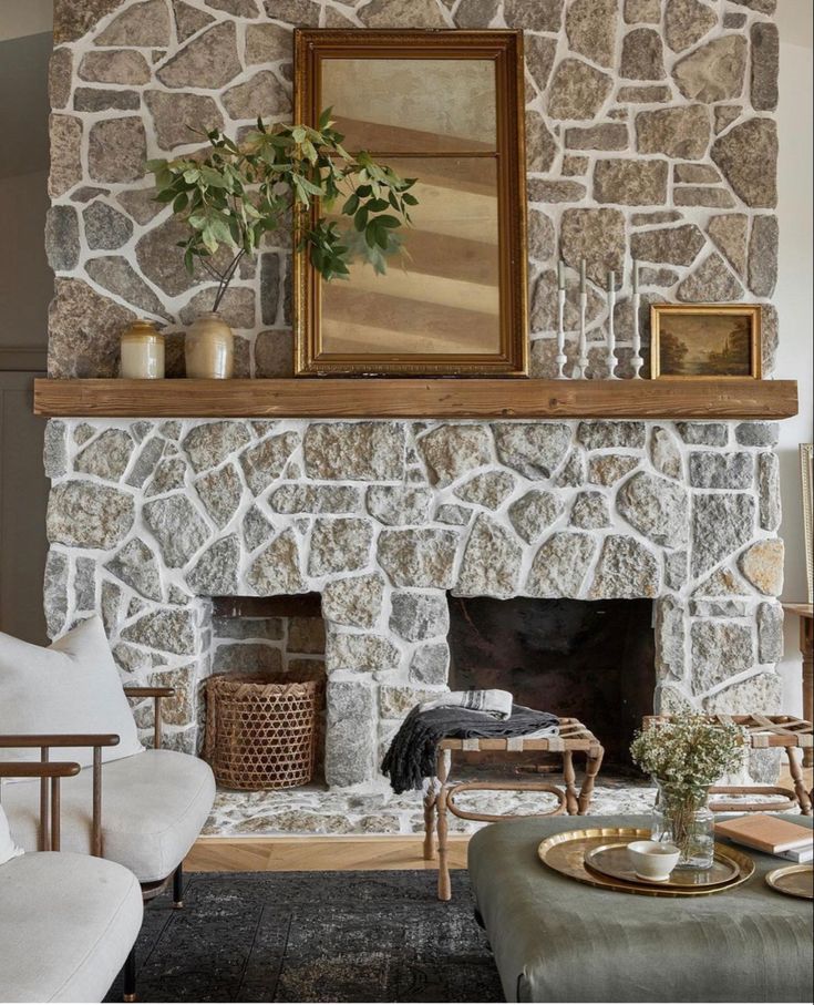 a living room with a stone fireplace and white furniture