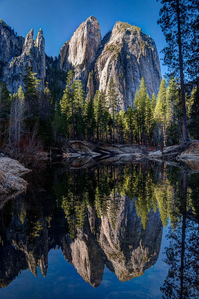 the mountains are reflected in the still water