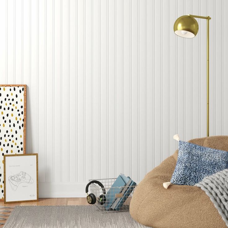 a living room with a bean bag chair, lamp and pictures on the wall behind it