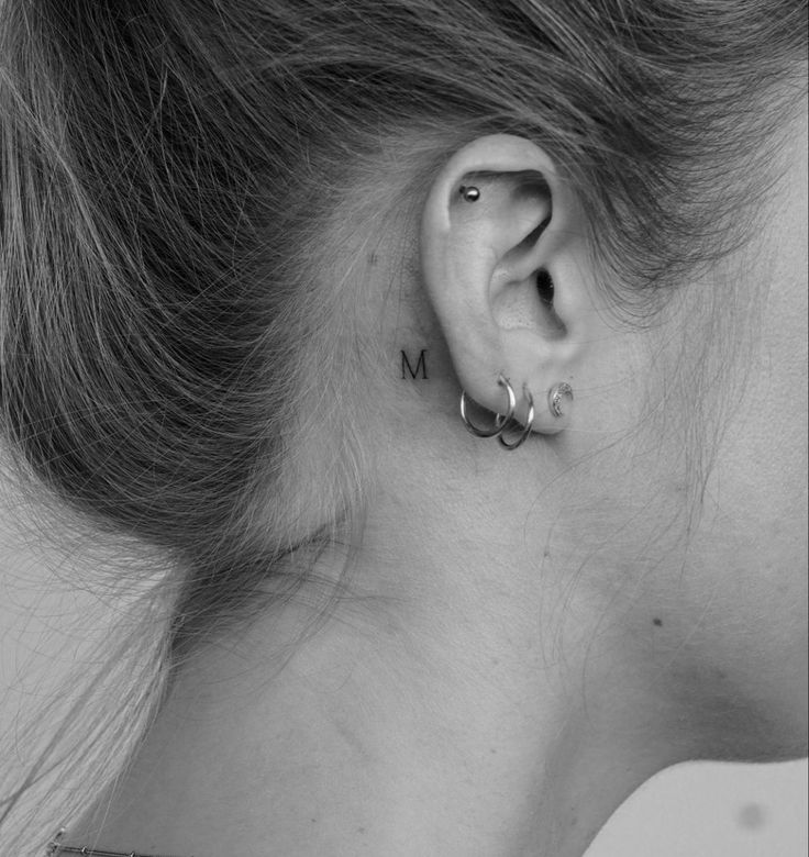 a woman's left ear with the word mom written in small letters on it