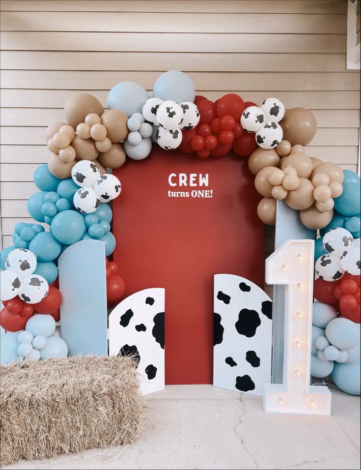 a cow themed birthday party with balloons and decorations on the front door, including a sign that says cream