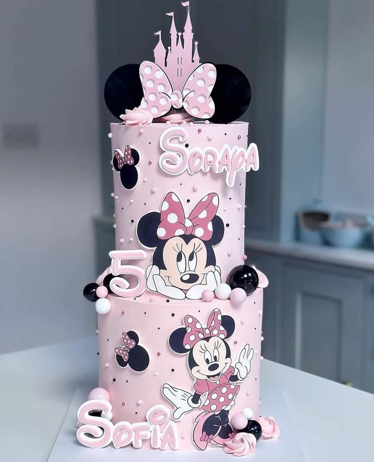 a three tiered cake with minnie mouse decorations