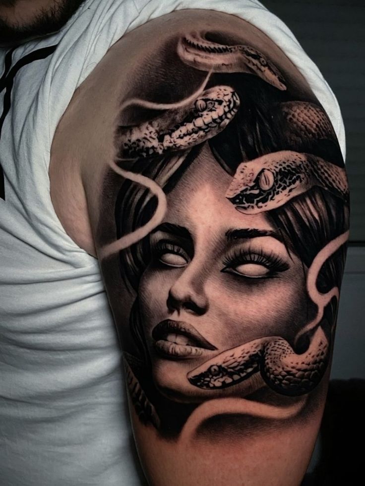 a man with a tattoo on his arm and head is holding a snake around his neck