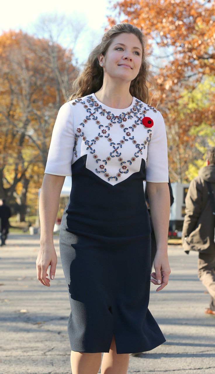 a woman is walking down the street in a dress